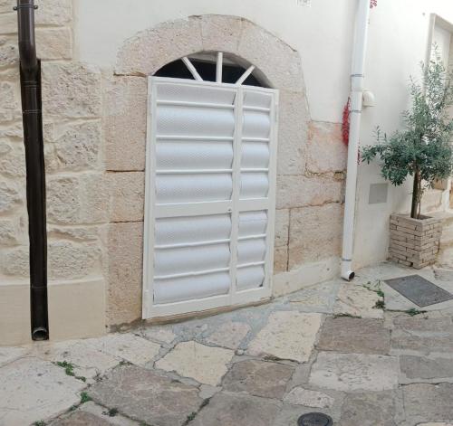 a white door in a stone building with a window at Casa Vacanza Altamura in Altamura