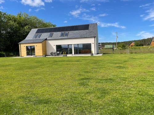 a house with a large green field in front of it at Ash Mill - Dornoch in Dornoch