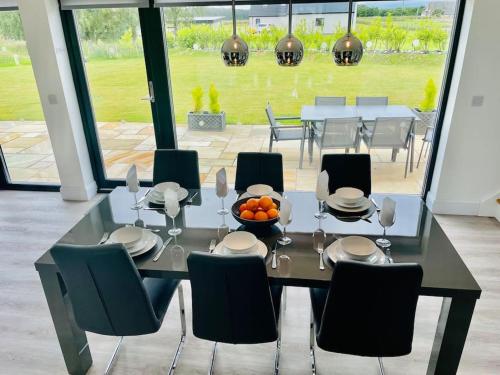 a dining room table with chairs and a bowl of oranges on it at Ash Mill - Dornoch in Dornoch