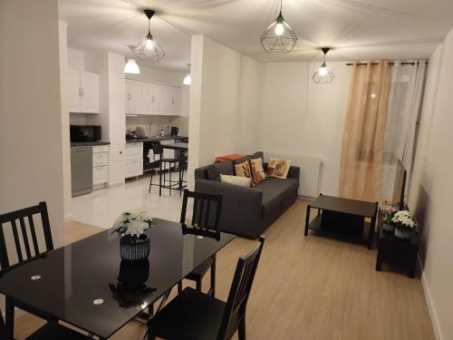 Il comprend un salon et une cuisine avec une table et un canapé. dans l'établissement Apparemment familial, Évry-Courcouronnes