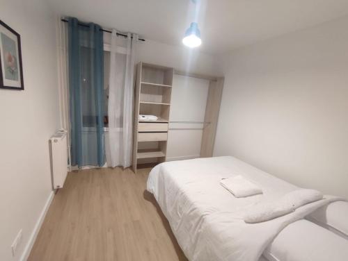 - une petite chambre blanche avec un lit et un placard dans l'établissement Apparemment familial, Évry-Courcouronnes