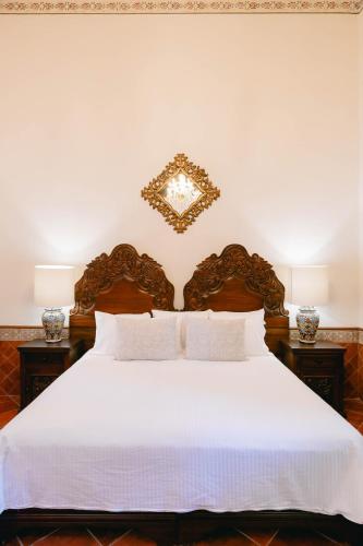 a bedroom with a white bed with two lamps at Hotel Hacienda La Cieneguita in San Miguel de Allende