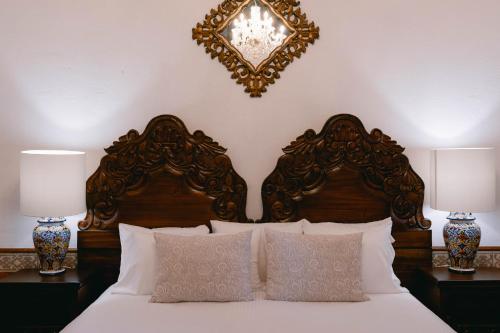 a bedroom with a bed with two lamps and a mirror at Hotel Hacienda La Cieneguita in San Miguel de Allende