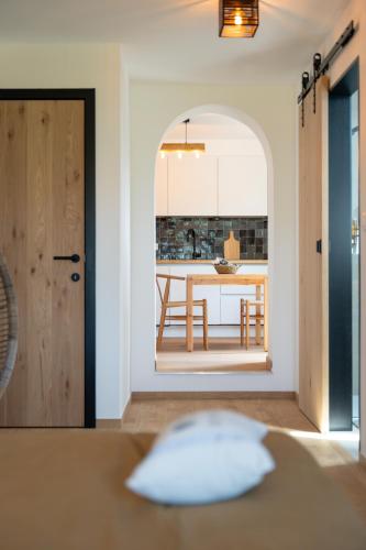 cocina y comedor con mesa y puerta en Le Cocon de Jeanne, en Hannut
