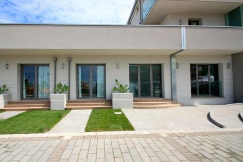 a large white building with windows and a courtyard at Hotel & Residence Cavalluccio Marino in Rimini