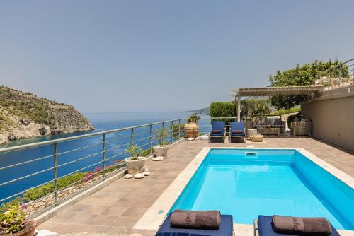 a swimming pool with a view of the ocean at Braunis Horio Villas in Asos