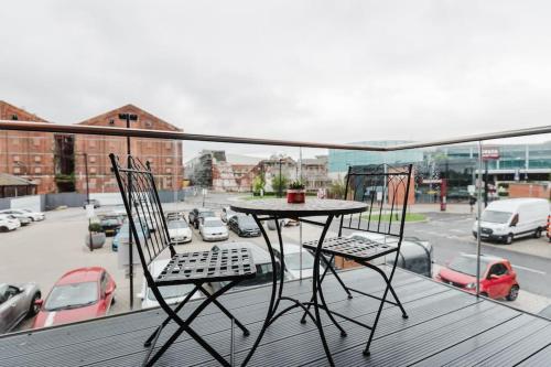 a table and chairs on a balcony with a view of a parking lot at Beautiful 1 Bedroom Apartment with parking in Gloucester Docks in Gloucester