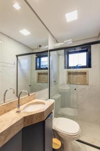 a bathroom with a toilet sink and a shower at Maranatha Suítes in Campo Grande