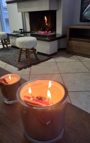 two candles sitting on a table in front of a fireplace at Blessed view in Keratea