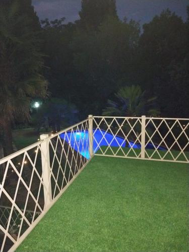 a white fence with green grass at night at De La Grace in Potchefstroom