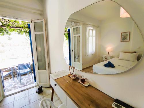 a bedroom with a bed and a mirror on the wall at Villa Le Grand Bleu in Katapola