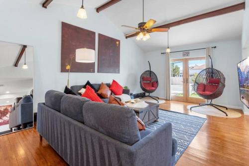 a living room with a gray couch and red pillows at AC Beach Farmhouse Retreat - 5BD 2BA in Atlantic City