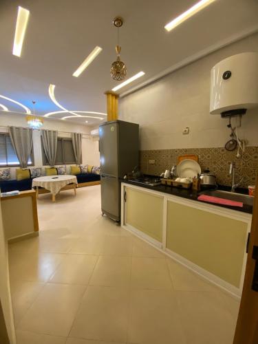 a kitchen with a refrigerator and a living room at مولاي يعقوب in Fès