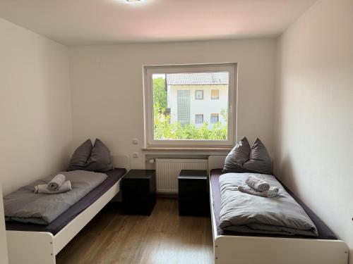 two beds in a room with a window at Ferienwohnung Adelsried 1 in Adelsried