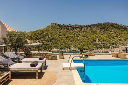 a resort with a pool with a mountain in the background at Braunis Horio Villas in Asos