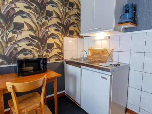 Una pequeña cocina con una mesa y un microondas. en La Rosée - Studio Bali - Wifi, Smart TV, en Bourbonne-les-Bains