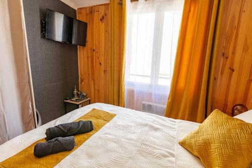 Un dormitorio con una cama con dos almohadas encima. en La Rosée - Studio Bali - Wifi, Smart TV, en Bourbonne-les-Bains