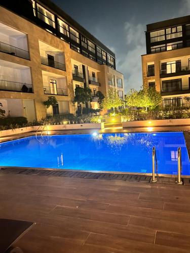a large blue swimming pool in front of a building at Embassy Gardens Royal Suites Apartments in Accra