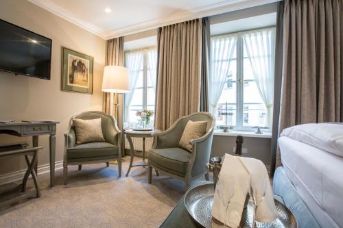 a hotel room with a bed and a desk and chairs at Romantik Hotel Zur Glocke in Trier