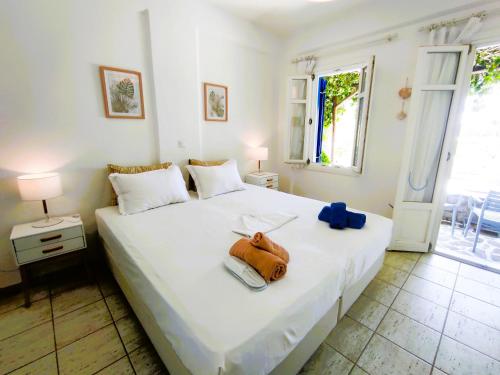 a bedroom with a white bed with a purse on it at Villa Le Grand Bleu in Katapola