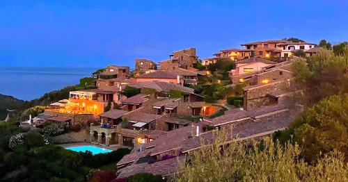 a group of houses on a hill at night at Trilocale PUNTA EST Vista Mare in Capo Coda Cavallo