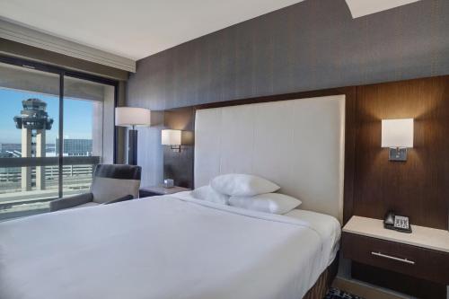 a hotel room with a large bed and a window at Hyatt Regency DFW International Airport in Dallas