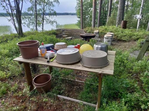 a table with pots and pans on top of it at Viihtyisä mökki järven rannalla in Sysmä