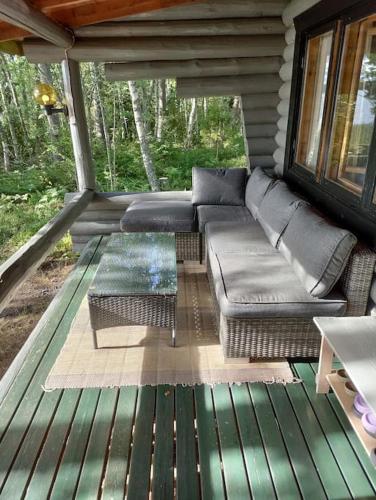 a screened in porch with a couch and a table at Viihtyisä mökki järven rannalla in Sysmä