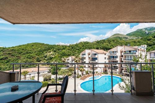 a balcony with a view of a pool and mountains at Blue Horison Apartments by In Property in Pržno