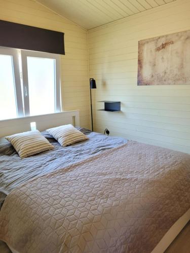 a bedroom with a bed with two pillows on it at Rustig gelegen chalet Solvo met terras aan het water in Geel