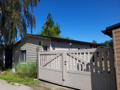 a house with a white fence and a garage at Rustig gelegen chalet Solvo met terras aan het water in Geel