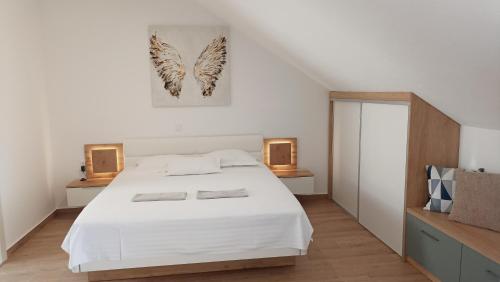 a bedroom with a large white bed and two lamps at The Father's House in Bol