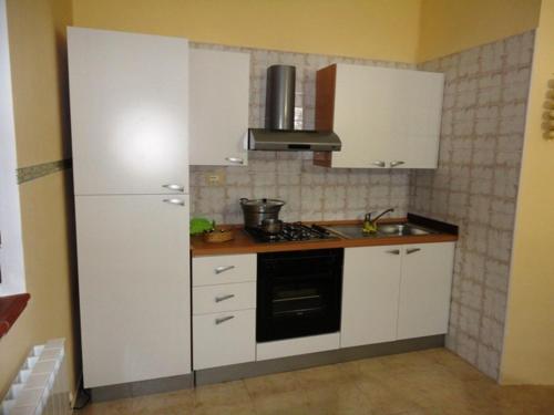 a kitchen with white cabinets and a stove top oven at Agriturismo Terre D'Ulivi in Moscufo