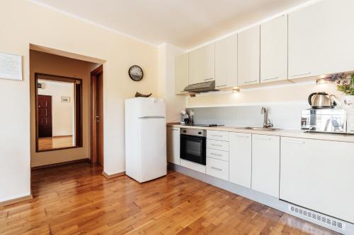 a kitchen with white cabinets and a refrigerator at Blue Horison Apartments by In Property in Pržno