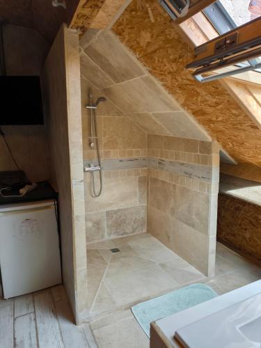 La salle de bains mansardée est pourvue d'une douche. dans l'établissement Madiana 89, à Bellechaume
