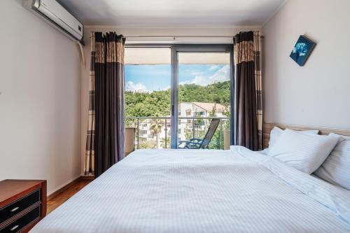 a bedroom with a bed and a large window at Blue Horison Apartments by In Property in Pržno