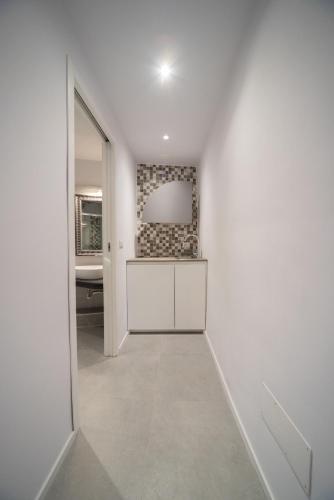 a hallway with a white room with a mirror at Palazzo Ricca Guarducci Piano Terra in Montefiascone
