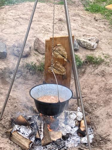 a pot of food is being stirred over a fire at Bell tent Boven Duin in 't Horntje