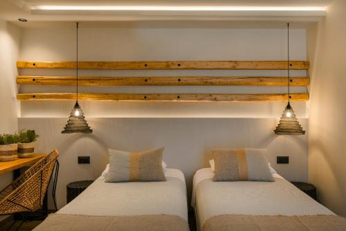 two beds in a room with two pendant lights at Braunis Horio Villas in Asos