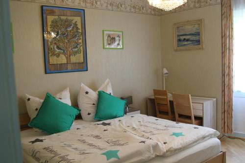 1 dormitorio con 1 cama con almohadas verdes en LebensART en Bad Dürrheim