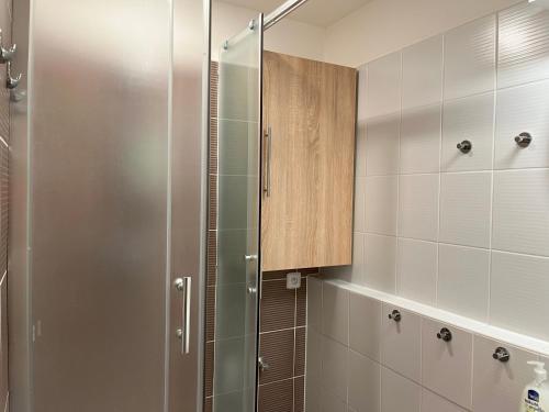 a bathroom with a shower with a wooden cabinet at Apartmán Fontána in Luhačovice