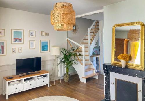 sala de estar con TV y chimenea en Le Jardin Des Délices charming house in Troyes, en Troyes