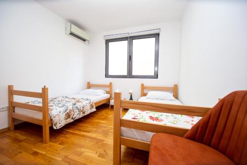 a room with two beds and a chair at Blue Horison Apartments by In Property in Pržno
