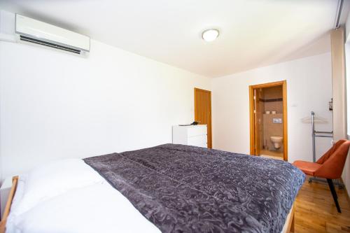 a bedroom with a bed and a chair at Blue Horison Apartments by In Property in Pržno