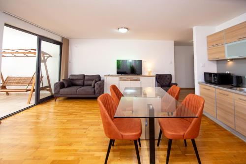 a kitchen and dining room with a glass table and chairs at Blue Horison Apartments by In Property in Pržno