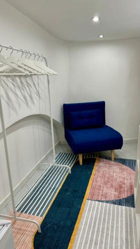 a blue chair and a bed in a room at Casa vacanza Nina in Salerno