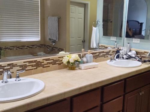 a bathroom with two sinks and a large mirror at Buena Vista home in Visalia