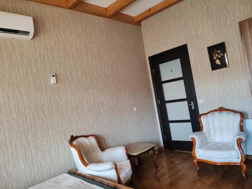 two chairs and a table in a room with a door at Golden Gate in Akhaltsikhe