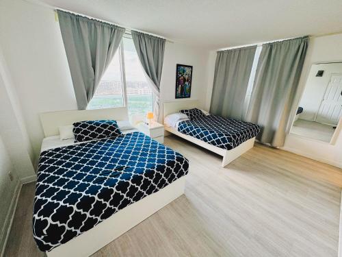 a bedroom with two beds and a window at Miami Hollywood High Rise Condo 004-22bvic in Hollywood
