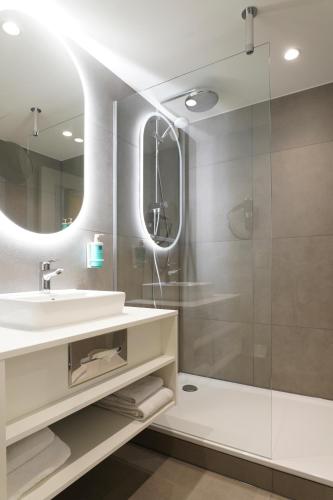 a bathroom with a sink and a shower at Novotel Antwerpen - Ekeren in Antwerp